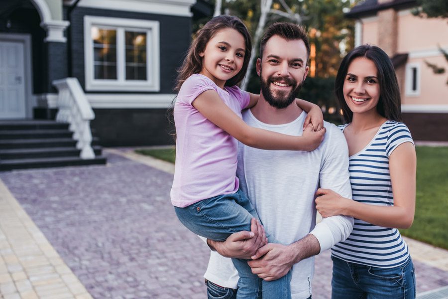 About Our Agency - Small Family Outside of a New Home Purchase in the Suburbs