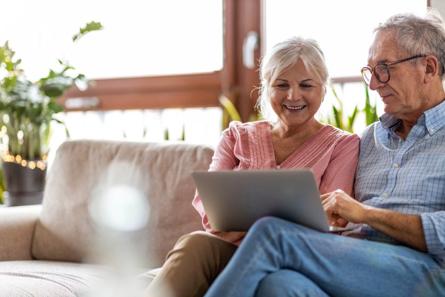 Personal Insurance - Older Couple Looking at a Laptop on the Couch
